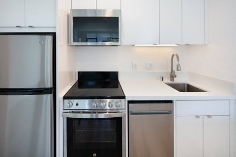 a kitchen with white cabinets and stainless steel appliances
