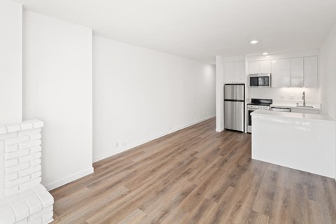 a bedroom with a medium sized bed and a kitchen with a stove and refrigerator