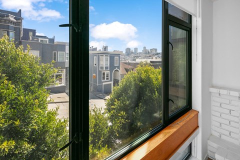a large window with a wooden ledge and a view of the city