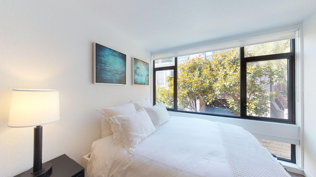 a bedroom with a large bed and a large window