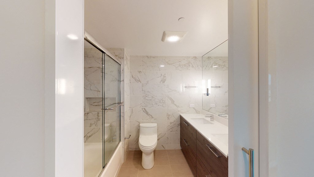 a bathroom with a toilet sink and shower in a 555 waverly unit