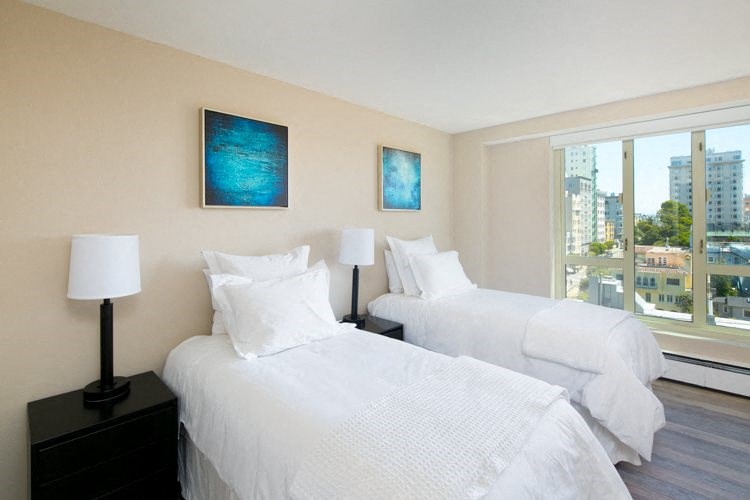 a bedroom with two beds and a large window