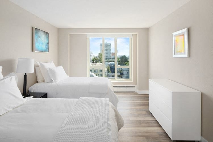 a bedroom with two beds and a large window