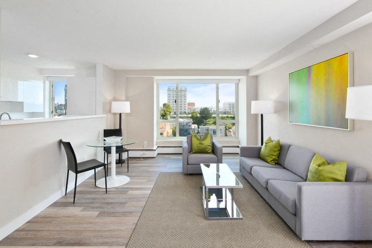 a living room with a gray couch and green pillows