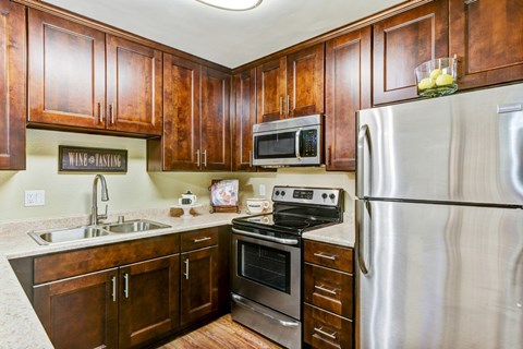 A kitchen with wooden cabinets and stainless steel appliances.