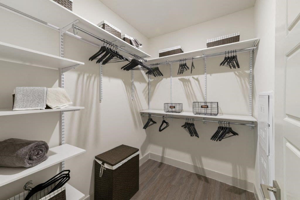 a walk in closet with white walls and shelves