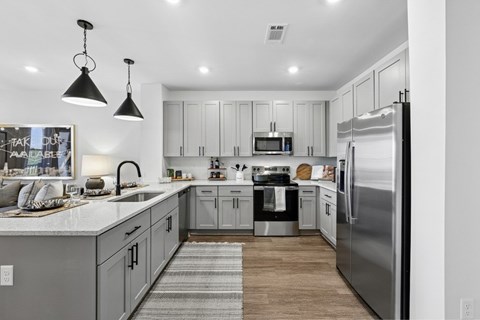 A modern kitchen with a refrigerator, sink, and cabinets.