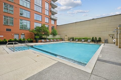 A large swimming pool in front of a red brick building.