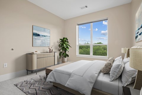A bedroom with a large bed and a painting on the wall.