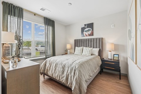 A bedroom with a large bed and a window with a view of the outside.