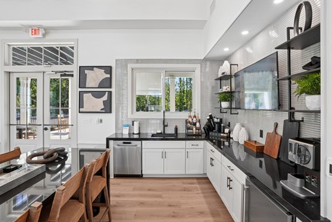A modern kitchen with a black countertop and white cabinets.