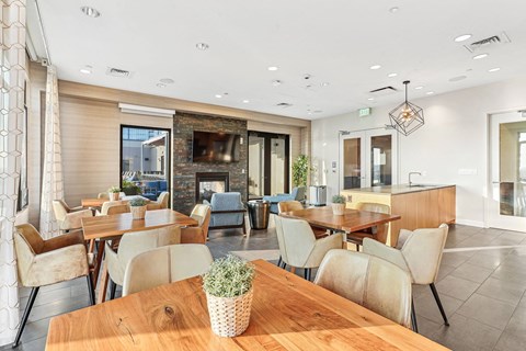 a dining room with tables and chairs and a living room with a fireplace