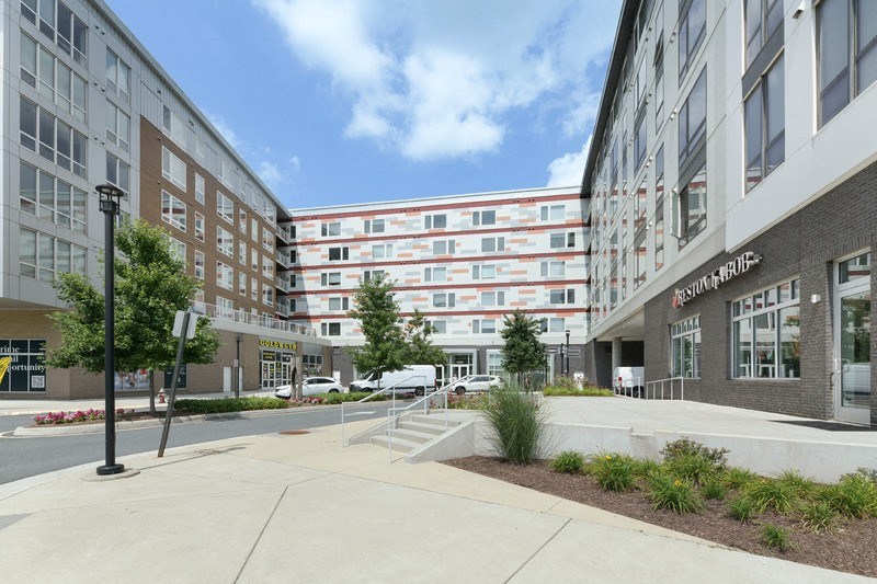 a picture of a large apartment building with a parking lot in front of it