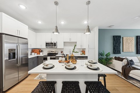 A modern kitchen with a dining table set for two.