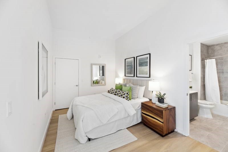 A bedroom with a bed, nightstand, and two framed pictures on the wall.