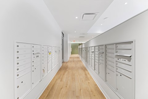 A long hallway with a series of mailboxes on the wall.