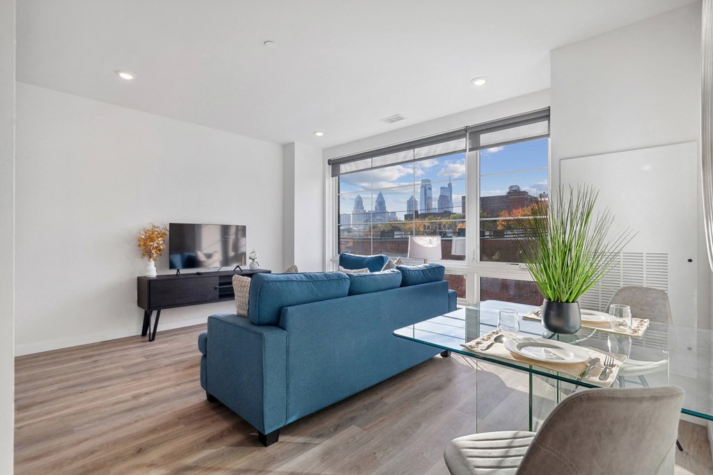 a living room with a blue couch and a glass coffee table