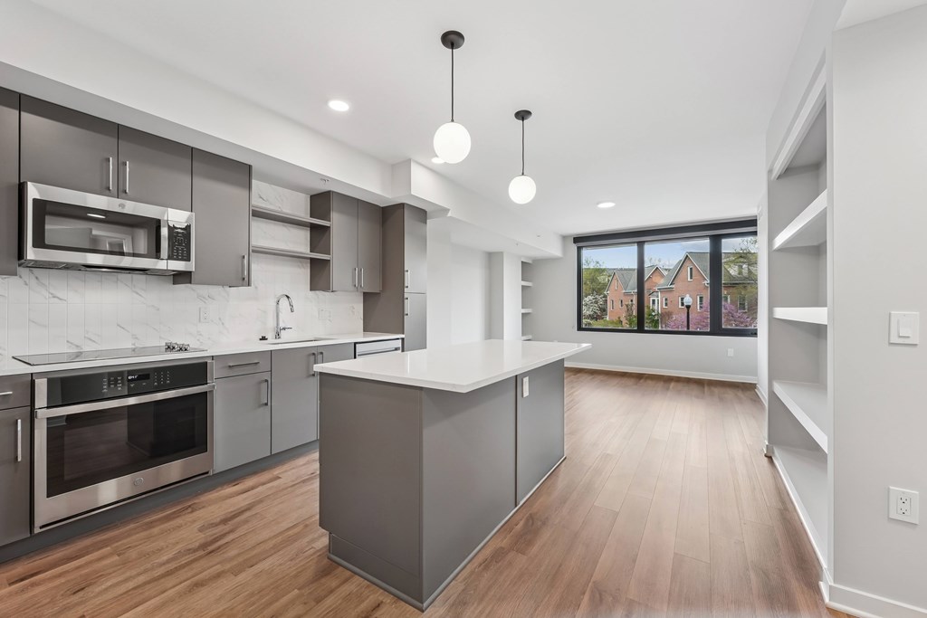 A modern kitchen with a large island and stainless steel appliances.