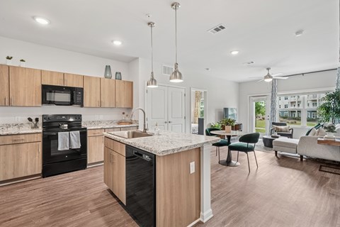 A modern kitchen with wooden cabinets and a black oven.