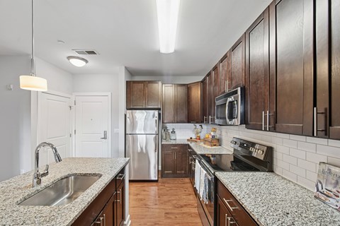 A kitchen with wooden cabinets and granite countertops.
