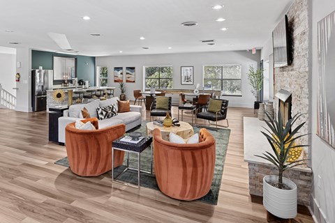 A living room with a white couch and orange chairs.