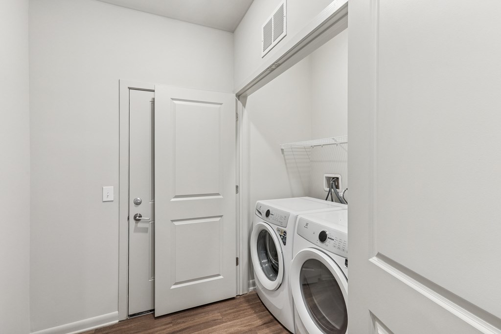 A white laundry room with a washer and dryer.