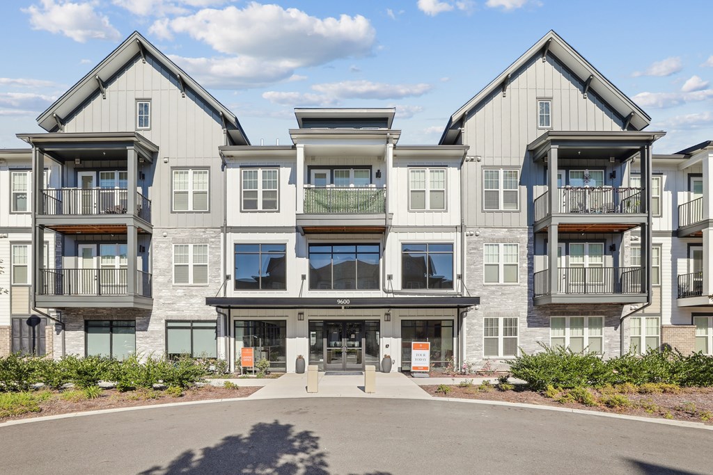 A row of modern townhouses with balconies and doors.