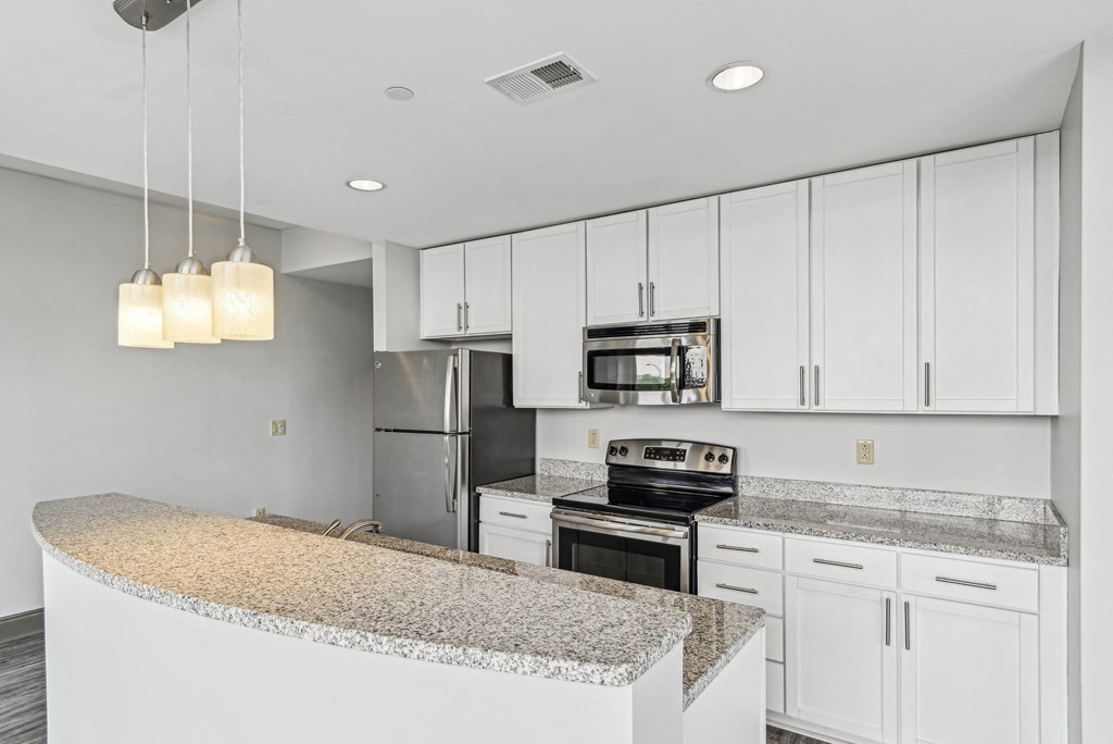 a kitchen with white cabinets and granite counter tops