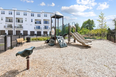 A playground with a slide, swings, and a merry-go-round.