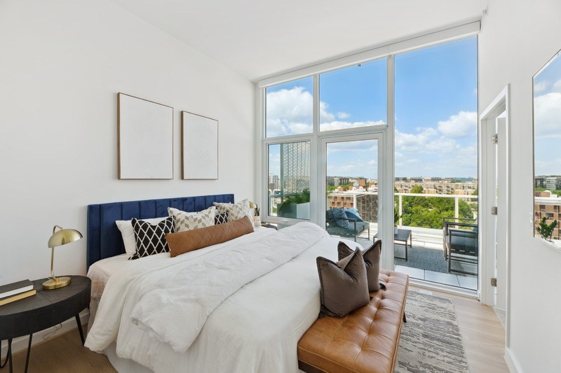 A bedroom with a large bed and a view of the city.