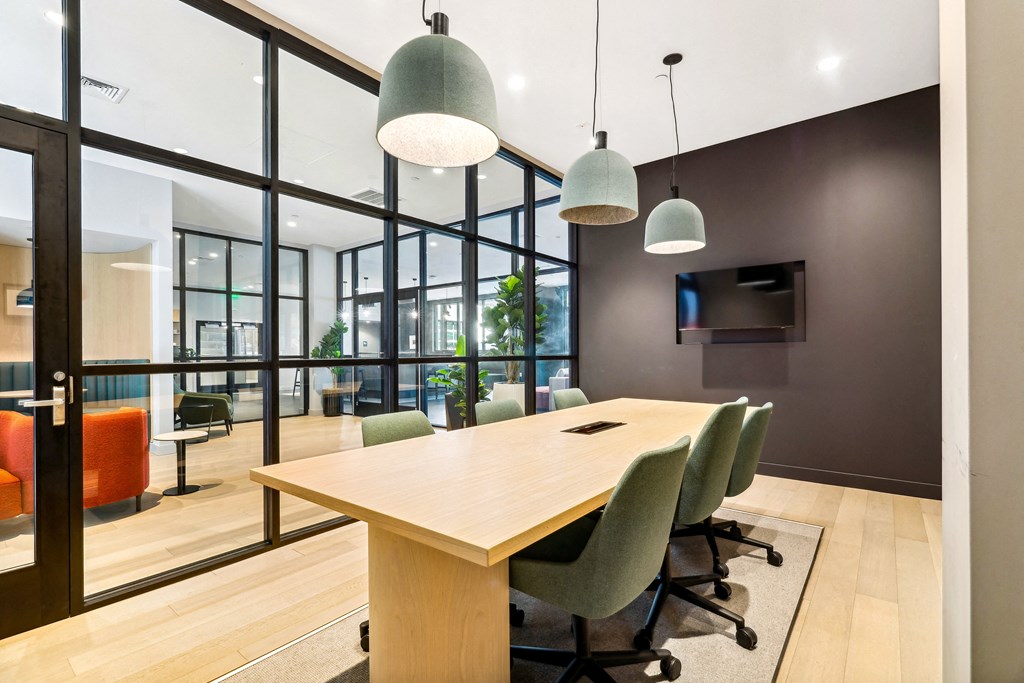 a conference room with a wooden table and chairs and large windows