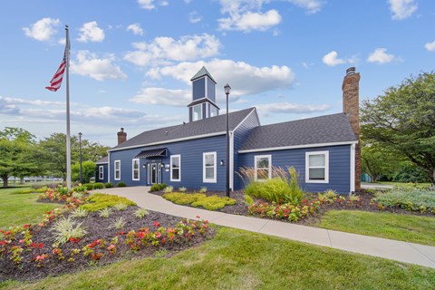 A blue building with a bell tower and a flag on a sunny day.