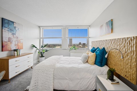 A bedroom with a large bed and a view of the city.