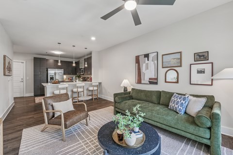 A living room with a green couch and a coffee table with a plant on it.
