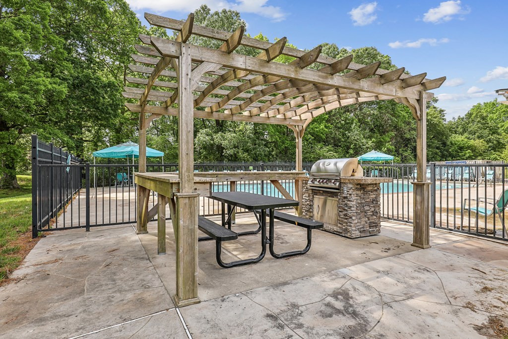 a picnic area with a grill and a pergola