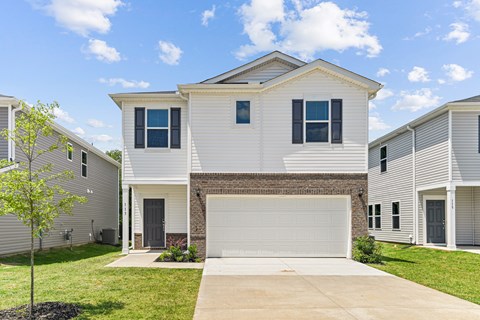 A white house with a grey roof and a garage door.