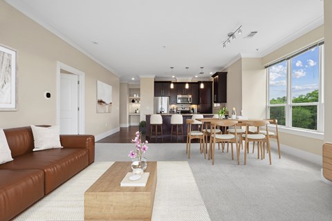 A modern living room with a brown leather couch and a wooden coffee table.