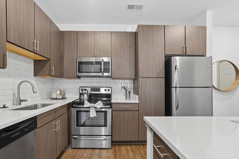 A modern kitchen with wooden cabinets and stainless steel appliances.