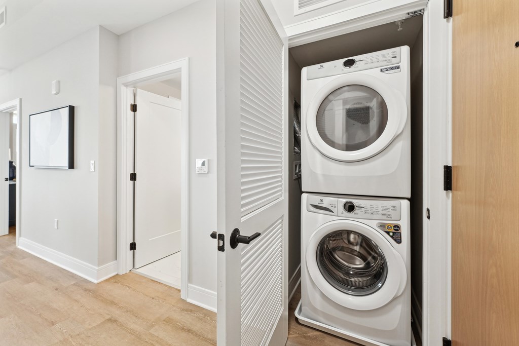 A white washing machine is in a cabinet in a room.
