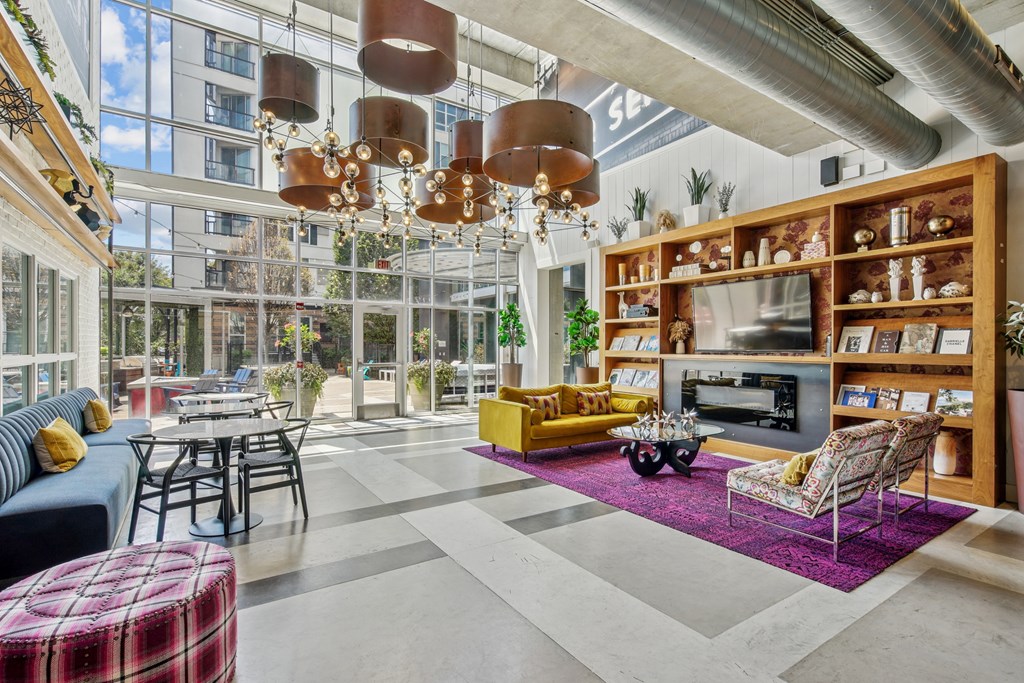 A modern living room with a large window and a variety of furniture.