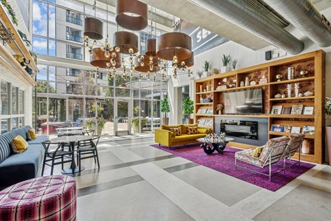 A modern living room with a large window and a variety of furniture.