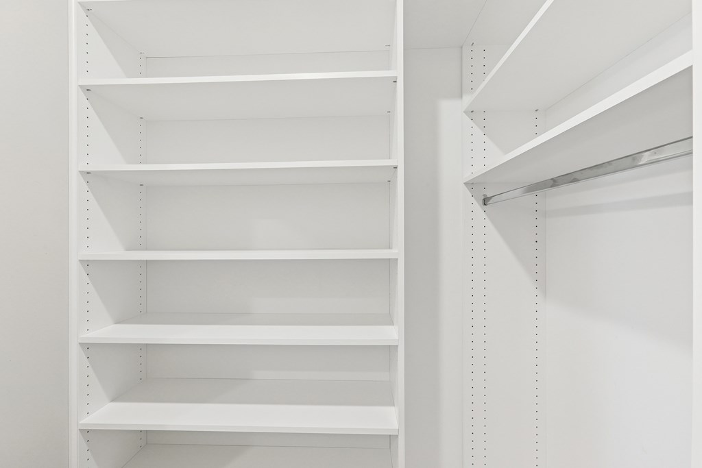 A walk in closet with custom shelves
