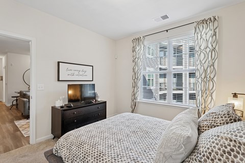 A bedroom with a large bed and a dresser with a mirror.