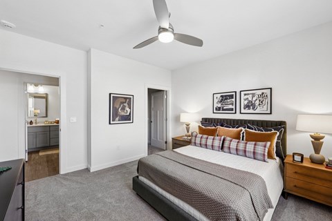 A bedroom with a large bed and a ceiling fan.