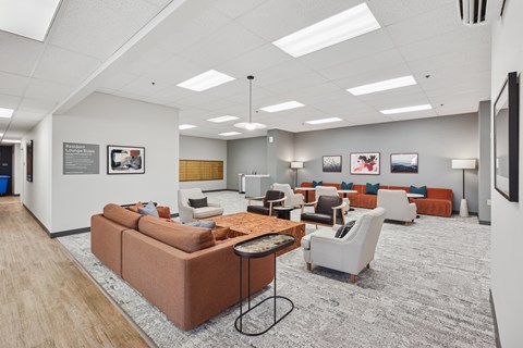 A spacious waiting room with a variety of seating options and pictures on the wall.