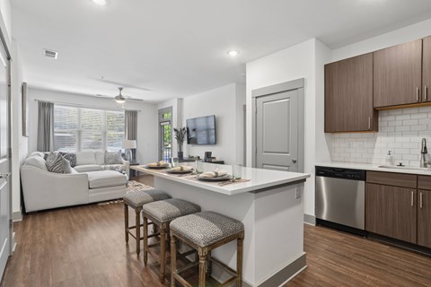 A modern kitchen with a white island and wooden floors.