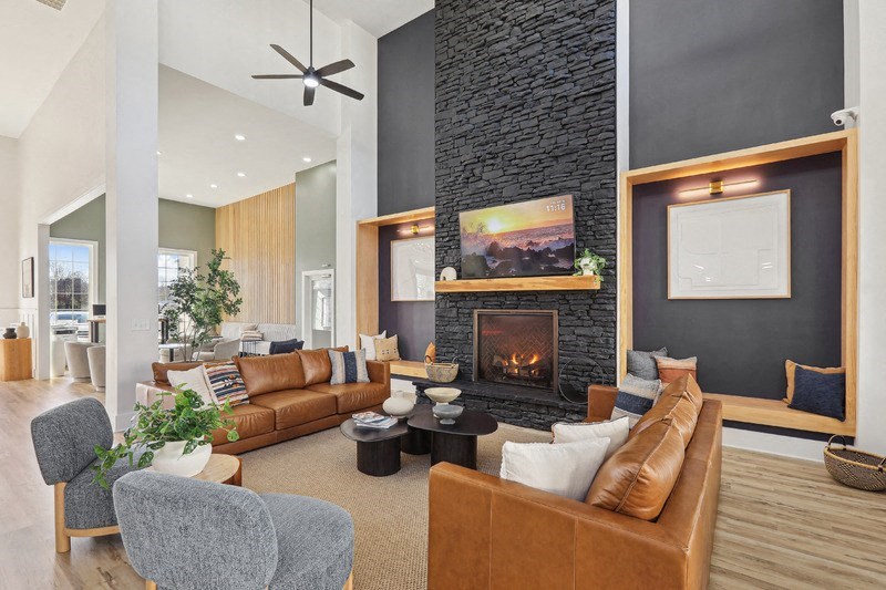 A modern living room with a fireplace and a ceiling fan.
