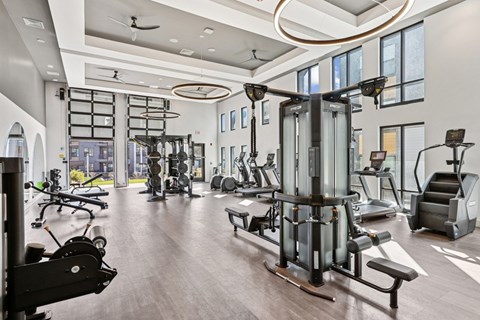 A spacious gym with a variety of equipment including treadmills, weights, and exercise machines.