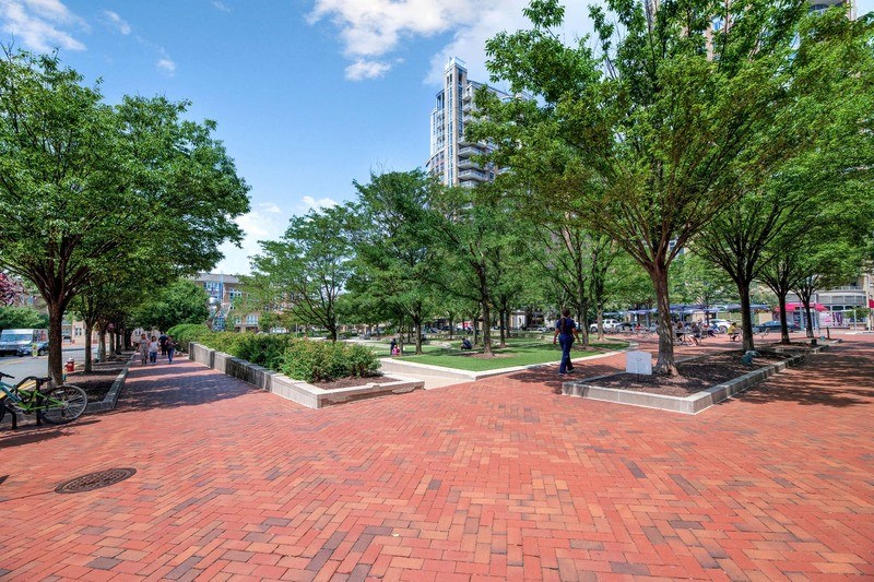 a park with trees and a red brick walkway