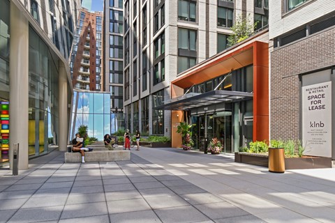 A modern building with a glass facade and a sign that reads "Restaurant Space for Lease".